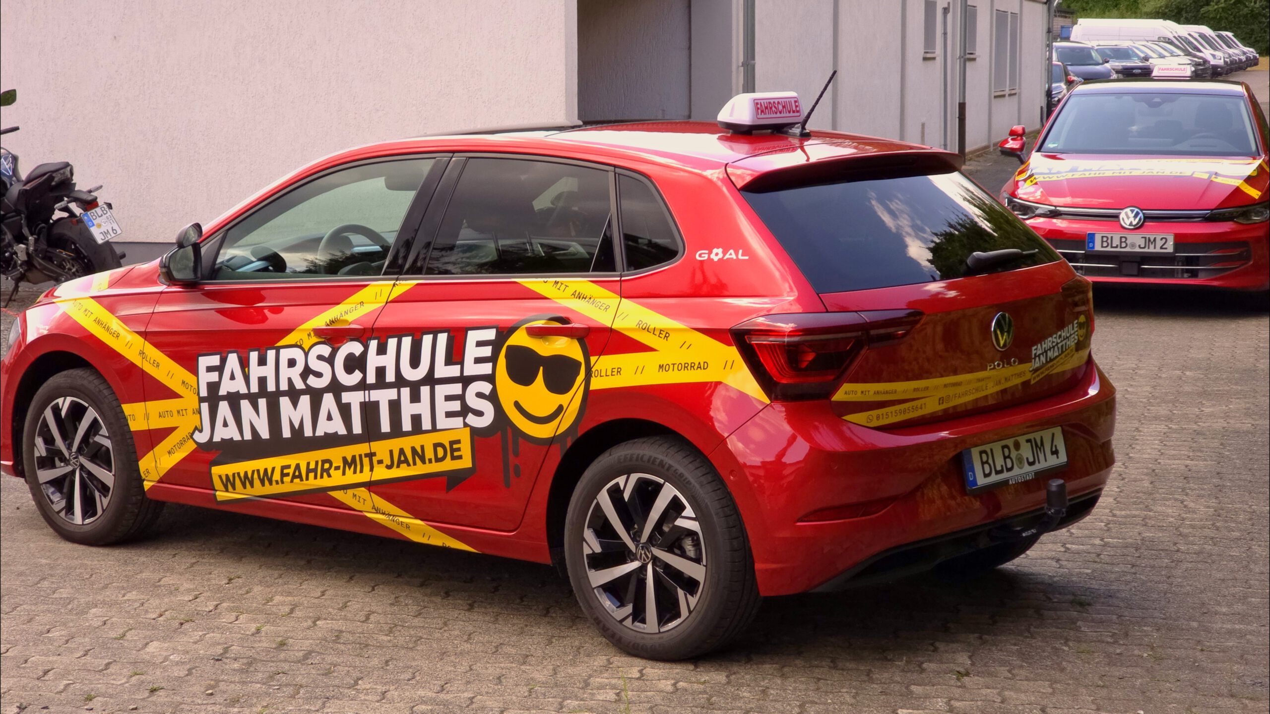 Seiten- und Heckansicht des roten VW Polo Fahrschulautos der Fahrschule Jan Matthes in Bad Berleburg mit auffälliger Beschriftung