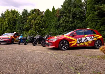 Zwei Fahrschulautos und mehrere Motorräder der Fahrschule Jan Matthes