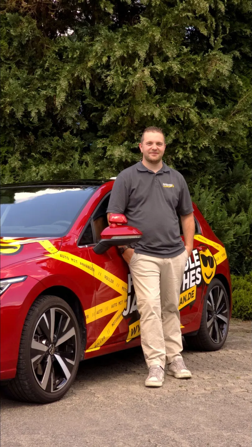Fahrlehrer Jan Matthes vor dem Fahrschulauto in Bad Berleburg