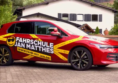 Seitenansicht des roten VW Golf 8 Fahrschulautos der Fahrschule Jan Matthes in Bad Berleburg für die Klassen B und BE